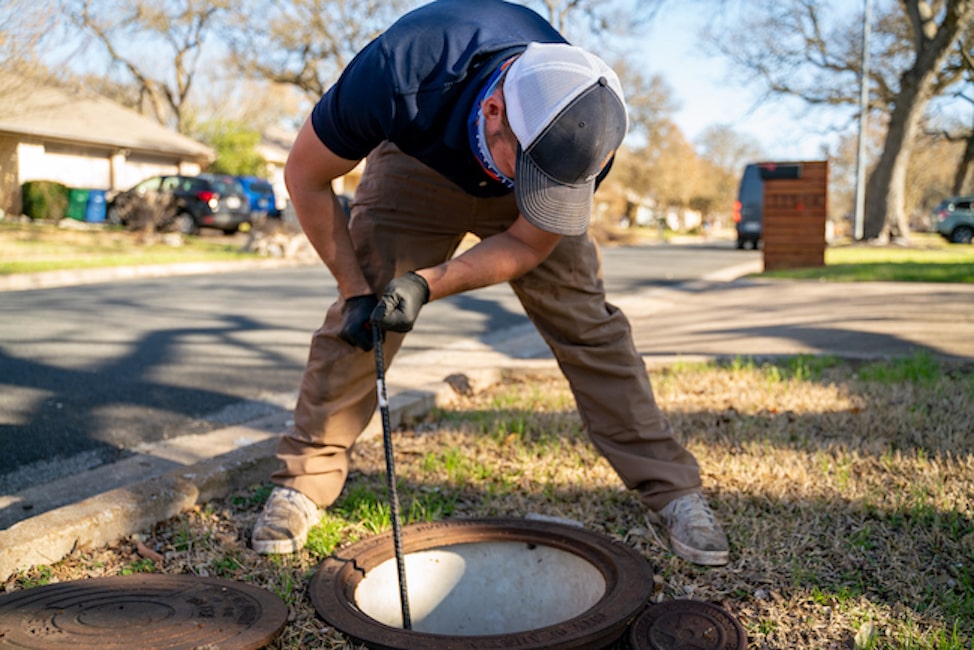Man working in an open sewer manhole