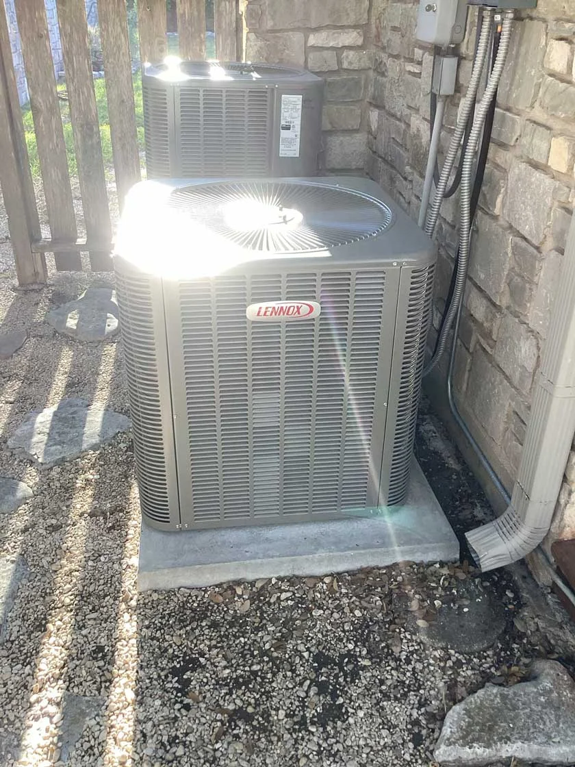 A Lennox HVAC Condenser system installed outside a home on a concrete slab