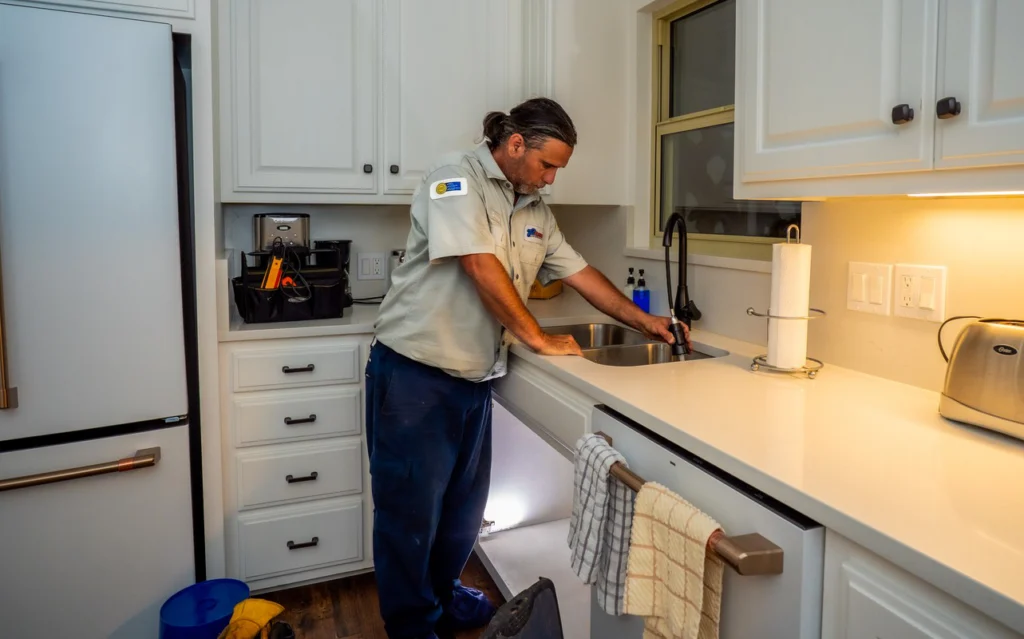 Professional Plumber Inspecting Kitchen Sink - Fredericksburg, TX