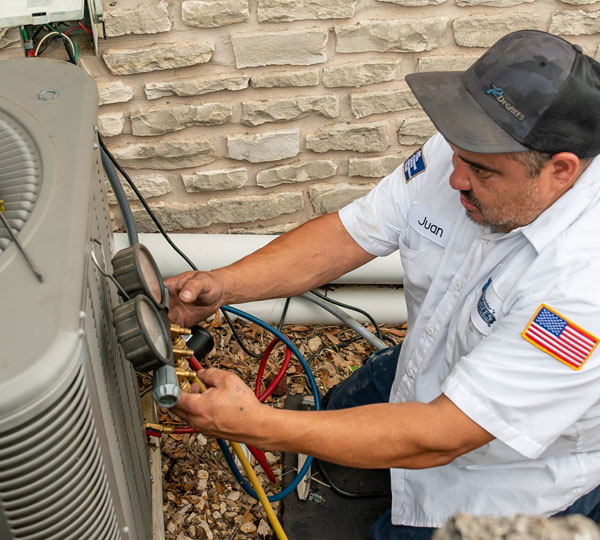 Technician performs maintenance on an air conditioning unit