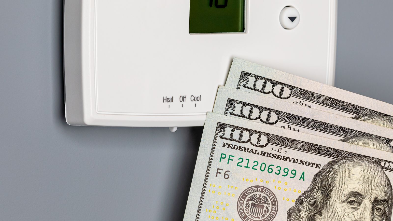 Thermostat and money representing inefficient furnace usage