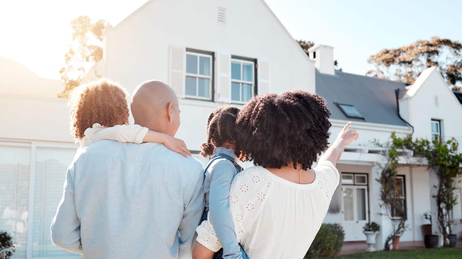 A family happily looking at their home.