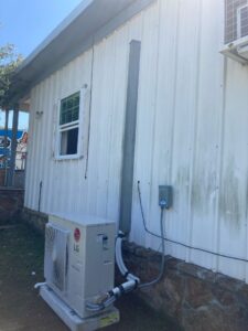 The compressor of a newly installed mini-split system outside a home